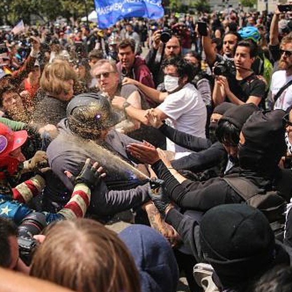 BERKELEY, USA - APRIL 15 : Trump supporters (L) clash with anti-Trump demonstrators (R) during a pro-Trump rally in Berkeley, USA on April 15, 2017. A large number of fights have occurred and people w ...