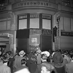 Nachdem Jugendliche am Tag der Kapitulation am 8. Mai 1945 das Deutsche Verkehrsbüro in der Zürcher Bahnhofstrasse beschädigt haben, wird der Schriftzug des Geschäfts verdeckt.