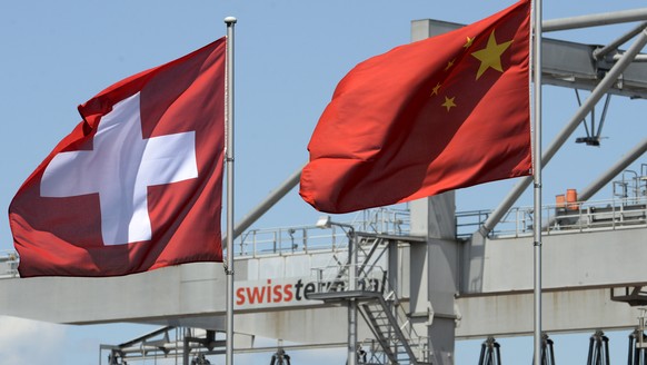 Die Schweizerflagge und die chinesische Flagge flattern im Wind, am Dienstag, 1. Juli 2014, im Rheinhafen in Basel. Heute tritt das Freihandelsabkommen der Schweiz mit China in Kraft. Unterzeichnet wo ...