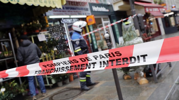 epa10377092 A police officer stands behind a cordon in 'Rue d'Enghien' after a shooting incident near a Kurdish cultural center in Paris, France, December 23, 2022. The Paris police prefecture has announced…