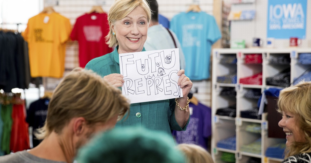 Democratic presidential candidate Hillary Clinton holds up a sign a girl gave her that reads "Future President" as she tours Raygun, a printing, design and clothing company, in Des Moines, I ...