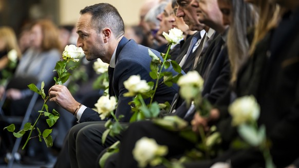 Mathias Reynard, State Councillor and president of the Council of State of the Canton of Valais, smells a white rose, during the official commemorative ceremony and the national day of mourning follow ...