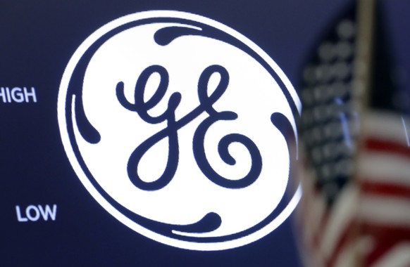 FILE - The General Electric logo appears above a trading post on the floor of the New York Stock Exchange, June 26, 2018. General Electric is splitting itself into three public companies that concentr ...