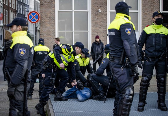 epa09750942 Policemen arrest a person after a protest against the coronavirus measures at the Binnenhof in The Hague, the Netherlands 12 February 2022. The action is inspired by the so-called Freedom  ...