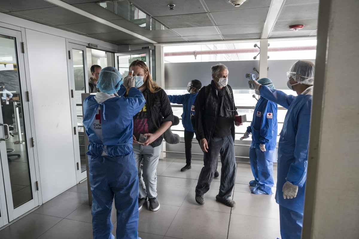 Gesundheitsbeamte messen vor dem Abflug die Koerpertemperatur von Schweizer Reisenden am Dienstag, 24. Maerz 2020 am Flughafen von Bogota, Kolumbien. Die Reisenden wurden wegen der Reise- und Aufentha ...