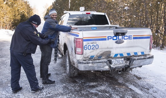 A Somali man is frisked by a Royal Canadian Mounted Police officer after crossing the U.S.-Canada border into Canada near Hemmingford, Quebec, on Friday, Feb. 17, 2017. A number of refugee claimants a ...