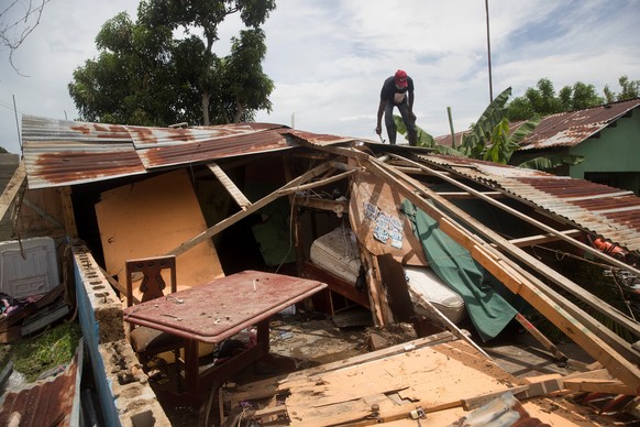 epa08577877 A man tries to repair his home damaged by Hurricane Isaias in Hato Mayor, Dominican Republic, 31 July 2020. Hundreds of Dominicans were struggling this Friday to recover their belongings i ...