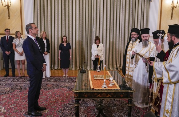 Greek Prime Minister Kyriakos Mitsotakis, left, takes the oath during an swearing-in ceremony at the Presidential Palace in Athens, Greece, Monday, June 26, 2023. Greece's centre-right leader…