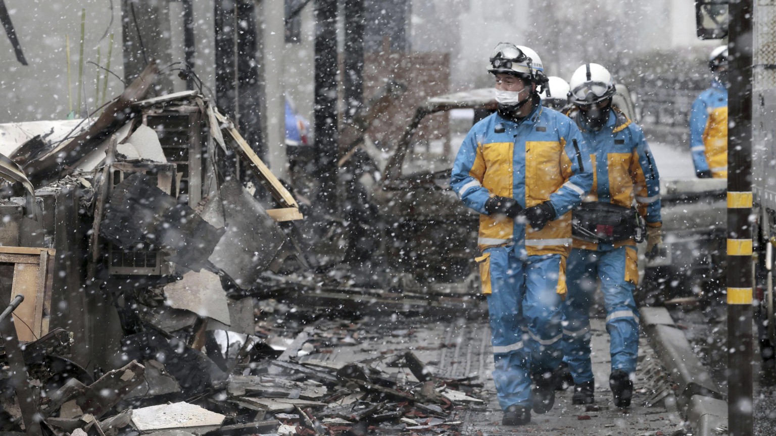 Police officers conduct a search operation at the site of a large fire occurred following an earthquake in Wajima, Ishikawa prefecture, Japan Saturday, Jan. 13, 2024. The powerful earthquake slammed t ...