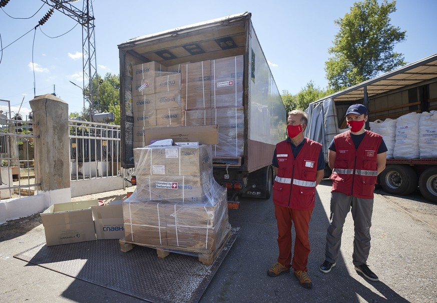Representatives of the Swiss humanitarian aid mission stand by Swiss trucks with antiseptic water, at a water pumping station close to Donetsk, Ukraine, Thursday, July 23, 2020. Swiss Federal Presiden ...