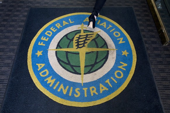 epa07434757 A woman walks over a carpet into the headquarters of the US Federal Aviation Administration (FAA) in Washington, DC, USA, 13 March 2019. The FAA announced the grounding of all Boeing 737 M ...