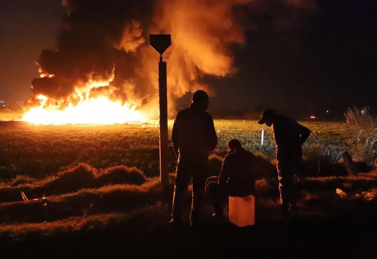 epaselect epa07298870 People wait in front of a wall of fire after an explosion of an illegal tap on Mexican oil company Pemex's pipeline in Tlahuilipan, state of Hidalgo, Mexico, late night 18 J ...