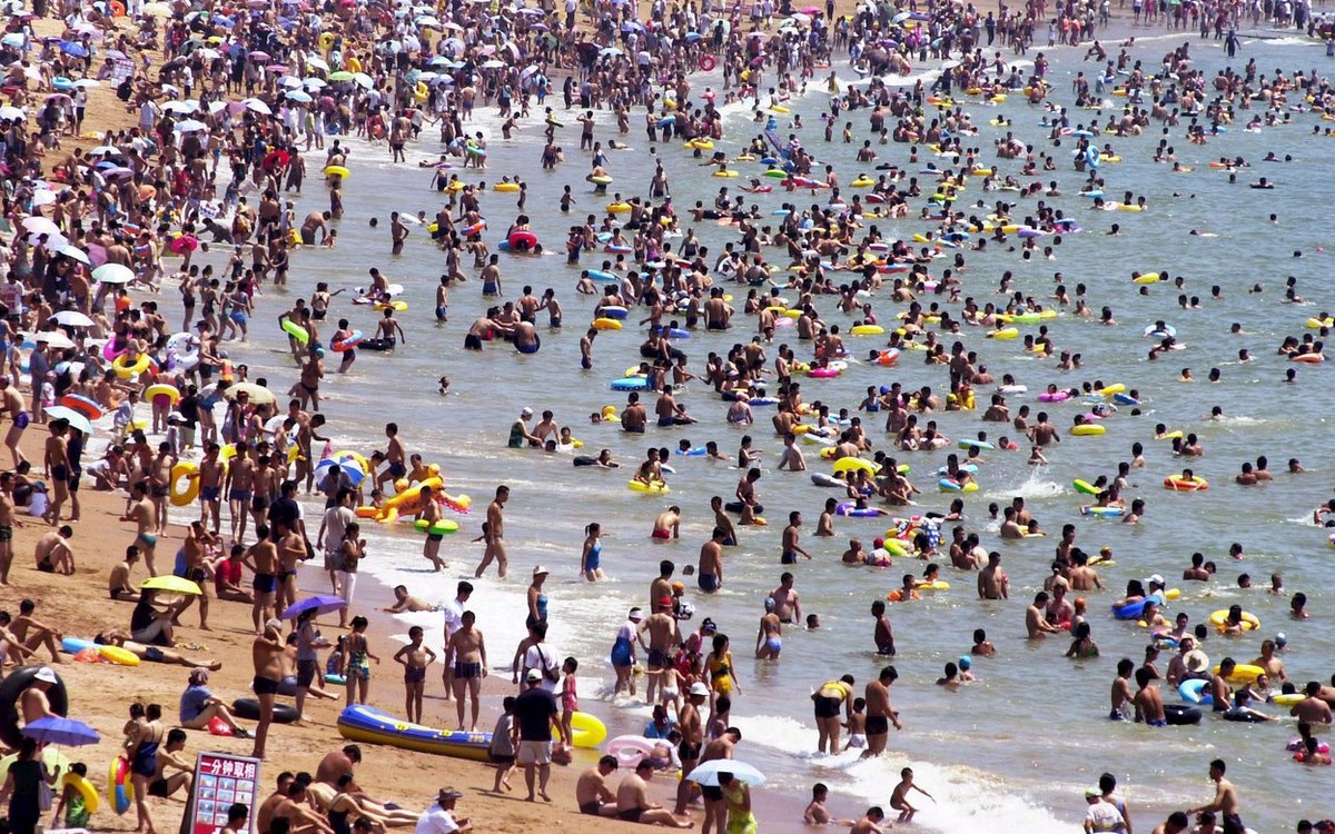 People enjoy their leisure time at the crowded 'Hui Quan Bay" near Qingdao city, China on Saturday, 13 August 2005. On hot summer days, up to 200,000 people use to pass their time at the bea ...
