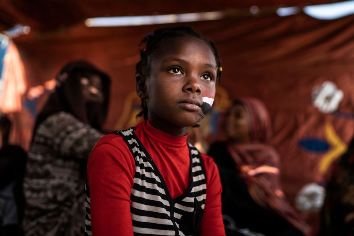 KHARTOUM, SUDAN - APRIL 27: A young girl and a group of women is relax in the early morning along a street where the protests against the military junta are being held on April 27, 2019 in Khartoum, S ...