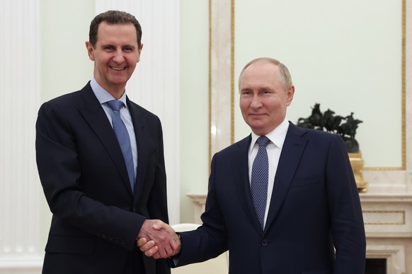 epa11495280 Russian President Vladimir Putin (R) and Syrian President Bashar al-Assad shake hands during their meeting at the Kremlin in Moscow, Russia, 24 July 2024 (issued 25 July 2024). EPA/VALERY  ...