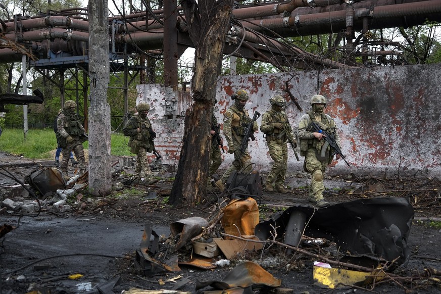 FILE - Russian troops walk in a destroyed part of the Illich Iron & Steel Works Metallurgical Plant in Mariupol, in territory under the government of the Donetsk People's Republic, eastern Uk ...