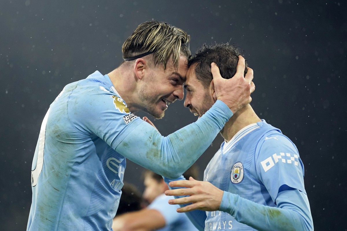 Manchester City's Jack Grealish celebrates with Bernardo Silva, right, after scoring his side's third goal during the English Premier League soccer match between Manchester City and Tottenha ...