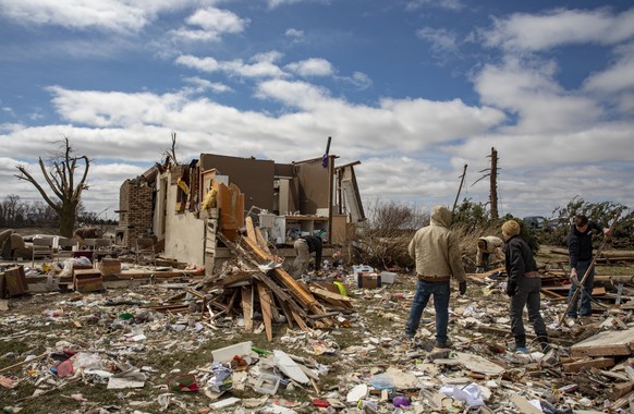 Family and neighbors look through debris on Ed Whestine&#039;s farm southwest of Wellman, Iowa on Saturday, April 1, 2023. Storms that dropped possibly dozens of tornadoes killed multiple people in sm ...
