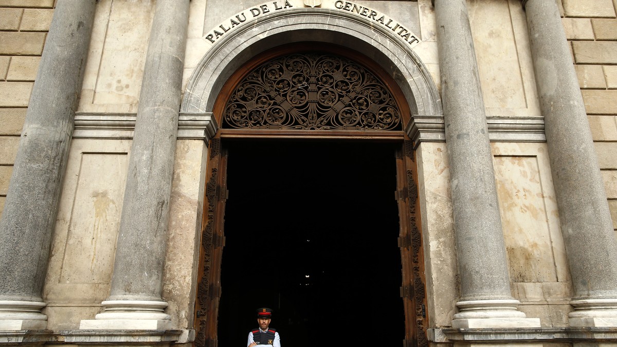 A Catalan police officer stands guard at the entrance of the Palau Generalitat in Barcelona, Spain, Monday Oct. 30, 2017. Catalonia's civil servants face their first full work week since Spain  ...