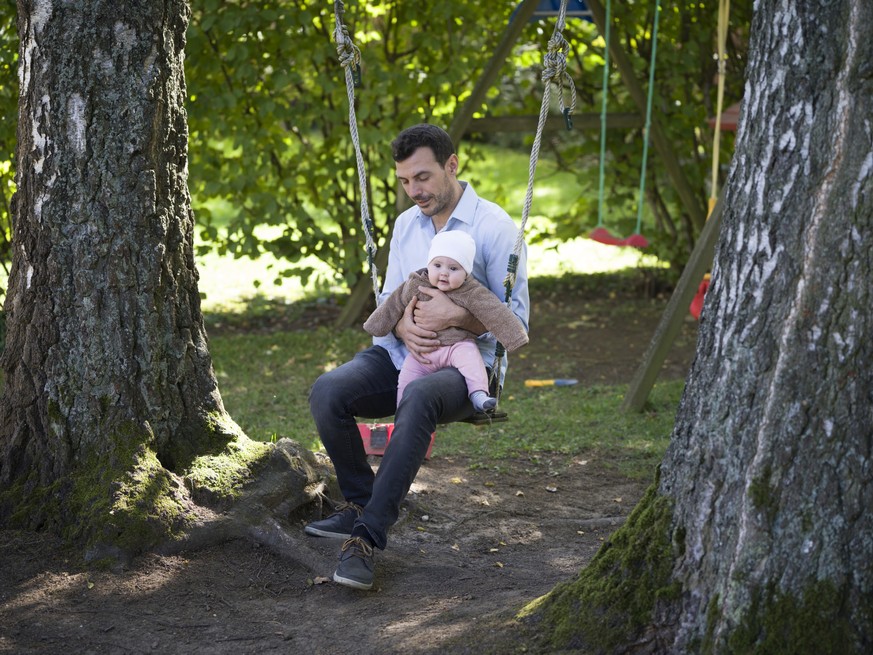 ARCHIV  ZUM THEMA VATERSCHAFTSURLAUB STELLEN WIR IHNEN FOLGENDES BILDMATERIAL ZUR VERFUEGUNG -- A father sits on a swing with his five-month-old daughter, pictured in Kilchberg, Canton of Zurich, Swi ...