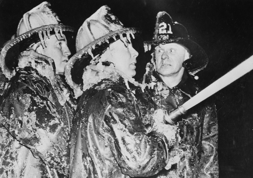 circa 1940: Three New York firemen with icicles dripping from their helmets struggle against the cold to put out a fire. (Photo by Weegee(Arthur Fellig)/International Center of Photography/Getty Image ...