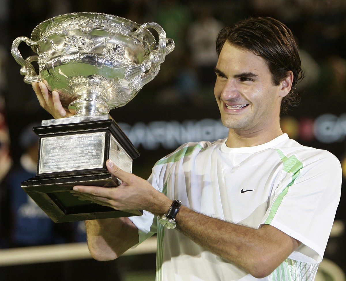 Switzerland's Roger Federer holds his trophy aloft after winning the men's singles final against Cypriot Marcos Baghdatis at the Australian Open tennis tournament in Melbourne, Australia, Su ...
