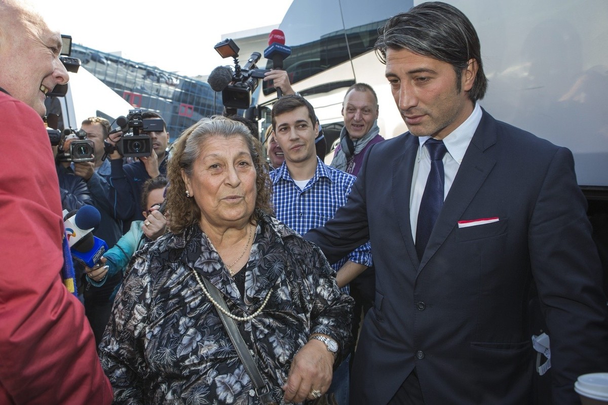 Murat Yakin, right, head coach of Switzerland's soccer team FC Basel, and his mother Emine, left, on their way to the bus in Bucharest, one day before the UEFA Champions League group E soccer mat ...
