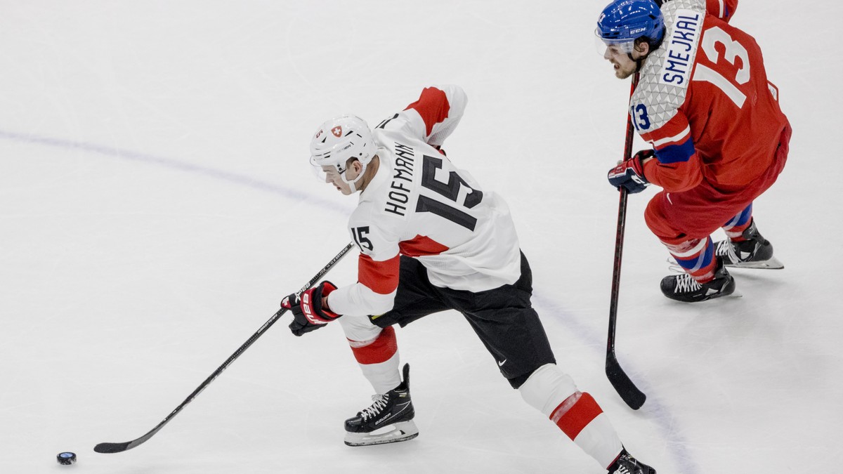 epa09746124 Jiri Smejkal (R) of the Czech Republic in action against Gregory Hofmann (L) of Switzerland during the Men's Ice Hockey preliminary round match between Czech Republic and Switzerland  ...