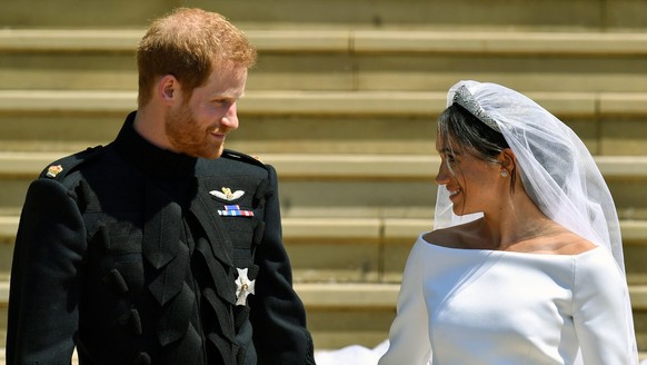 FILE - Prince Harry and Meghan Markle walk down the steps after their wedding at St. George&#039;s Chapel in Windsor Castle in Windsor, near London, England, Saturday, May 19, 2018. Britain