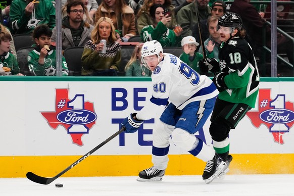 Tampa Bay Lightning defenseman J.J. Moser (90) takes control the puck in front of Dallas Stars center Sam Steel (18) in the first period of an NHL hockey game in Dallas, Sunday, Jan. 18, 2026. (AP Pho ...