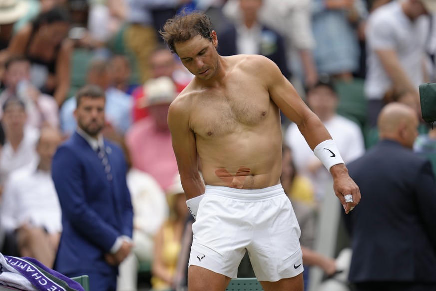 FILE - Spain&#039;s Rafael Nadal sports tape on his stomach following a medical timeout as he plays Taylor Fritz of the US in a men&#039;s singles quarterfinal match on day ten of the Wimbledon tennis ...