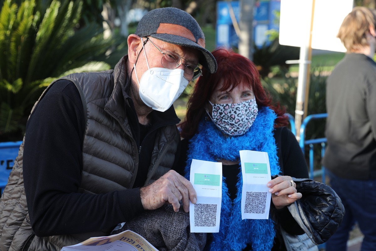 epa09033882 People present their coronavirus vaccination certificate or 'green badge' at the entrance of a music concert in Tel Aviv, 24 February 2021. Israel reopened cultural hubs for peop ...