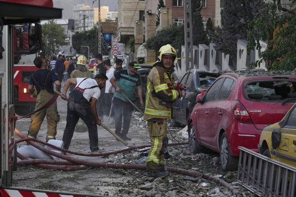 Firefighters and people clean up the scene of an explosion at a residence compound after Israeli attacks in Tehran, Friday, June 13, 2025. (AP Photo/Vahid Salemi)
Iran Mideast Wars