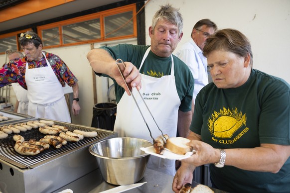 Mitglieder des 9er Clubs Aegerten grillen Wuerste fuer die Besucher bei der Bundesfeier am Montag, 31. Juli 2023 in Aegerten. Bundespraesident Alain Berset wird an der Bundesfeier eine Rede halten. (K ...