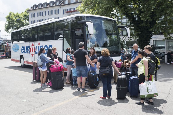 Menschen warten auf ihre Fernbuse auf dem Carparkplatz, aufgenommen am Samstag, 15. Juli 2017 in Zuerich. (KEYSTONE/Ennio Leanza)