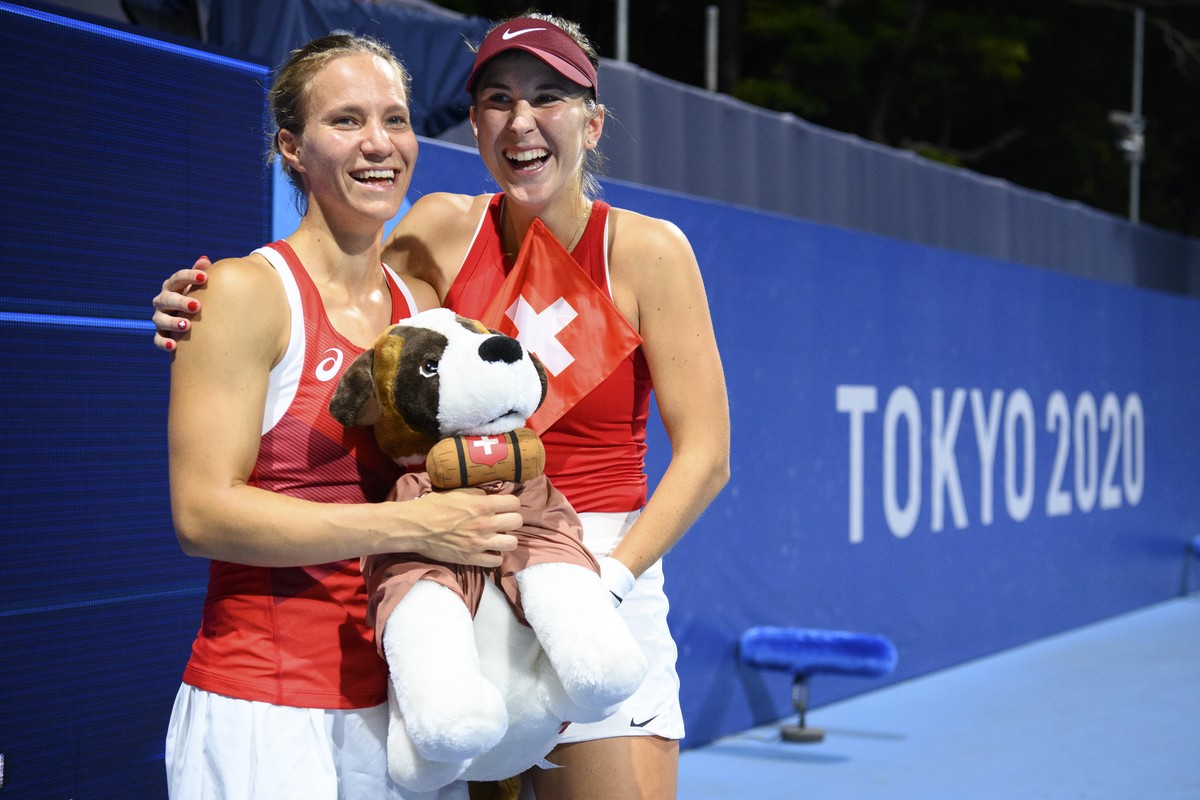 Belinda Bencic, right, and Viktorija Golubic, left, of Switzerland celebrate with the Swiss mascot dog Barry after winning against Laura Pigossi and Luisa Stefani of Brazil during the women's dou ...