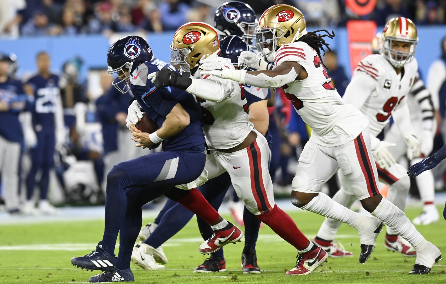Tennessee Titans quarterback Ryan Tannehill, left, is sacked by San Francisco 49ers defensive end Samson Ebukam, center, in the first half of an NFL football game Thursday, Dec. 23, 2021, in Nashville ...