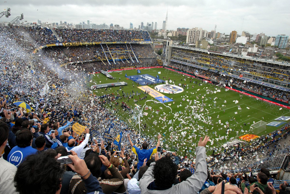 Fans of Boca Juniors cheer their team as the players ran onto the field to play against River Plate during an Argentina's first division soccer game at La Bombonera stadium in Buenos Aires. Sunda ...