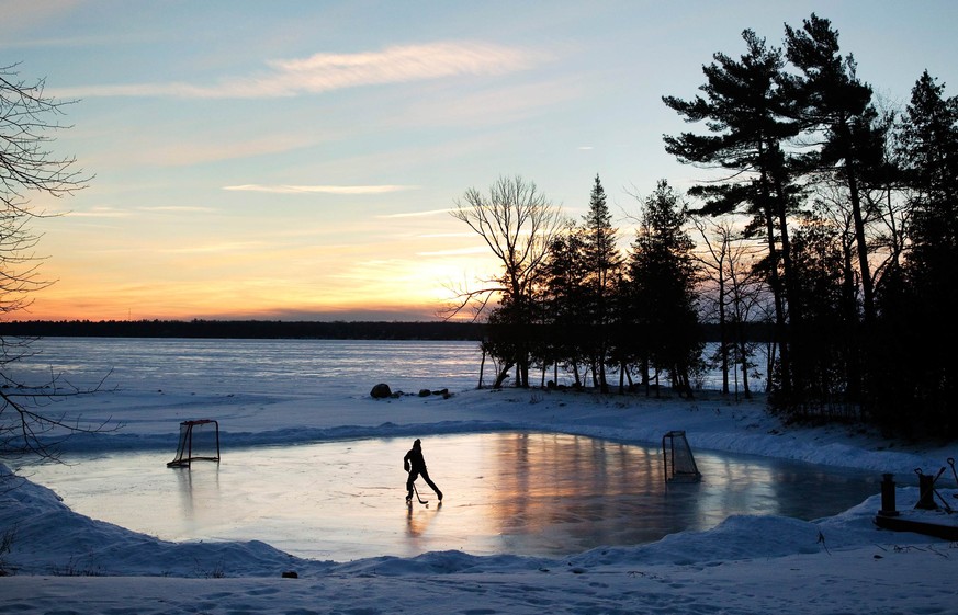 A youth plays pond hockey as the sun rises on Pigeon Lake in the region of Kawartha Lakes Ontario February 4, 2015. Hockey-mad Canadians are looking forward to one of the year's most anticipated ...
