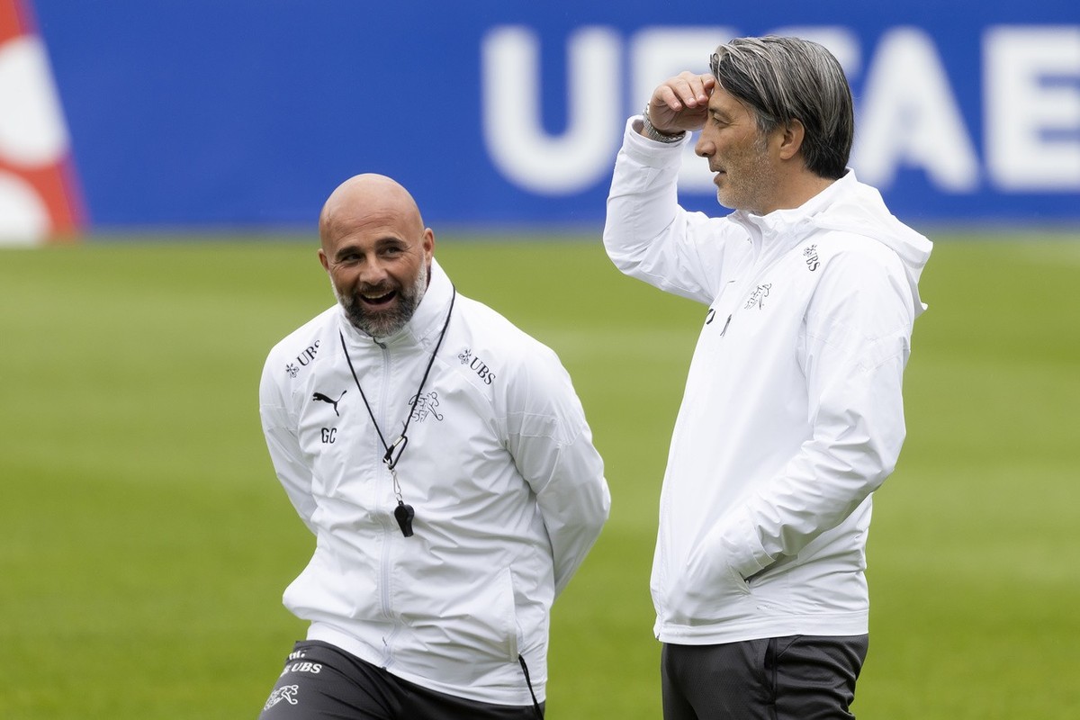 Switzerland's head coach Murat Yakin, right, and assistant coach Giorgio Contini react during a training session at the "Stadion auf der Waldau" in Stuttgart, Germany, Tuesday, July 2,  ...
