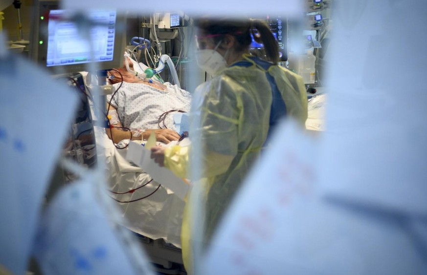 Eine Pflegefachperson kümmert sich im Spital in Neuenburg um einen Corona-Patienten (Symbolbild).