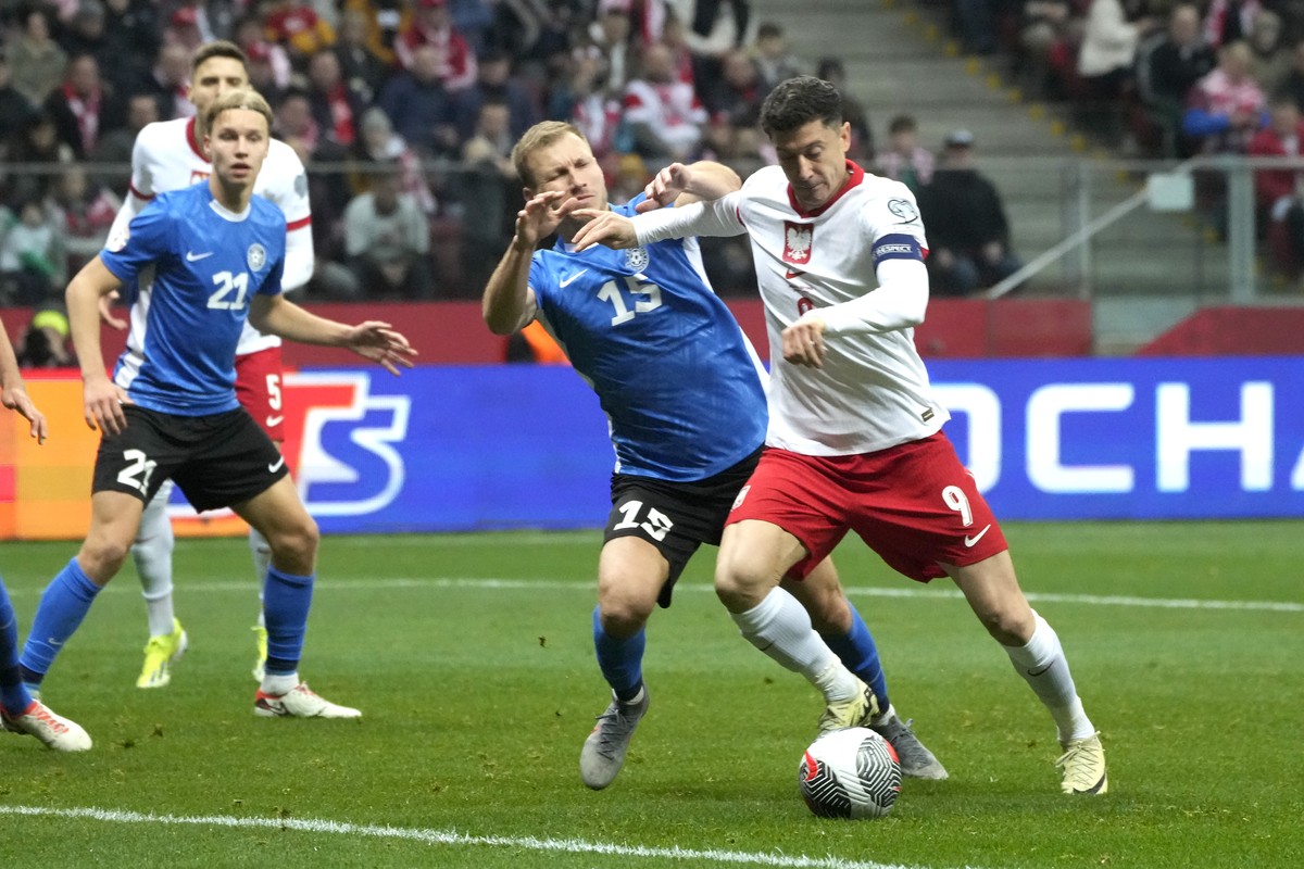 Poland's Robert Lewandowski, right, and Estonia's Ragnar Klavan fight for the ball during the Euro 2024 play off soccer match between Poland and Estonia at the National stadium in Warsaw, Po ...