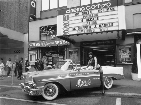 Ein Frau in leichter Bekleidung wirbt mit Cabriolet vor dem Kino Corso am Bellevue in Zuerich fuer den Film "Something Wild", aufgenommen im Jahr 1987. (KEYSTONE/Str)