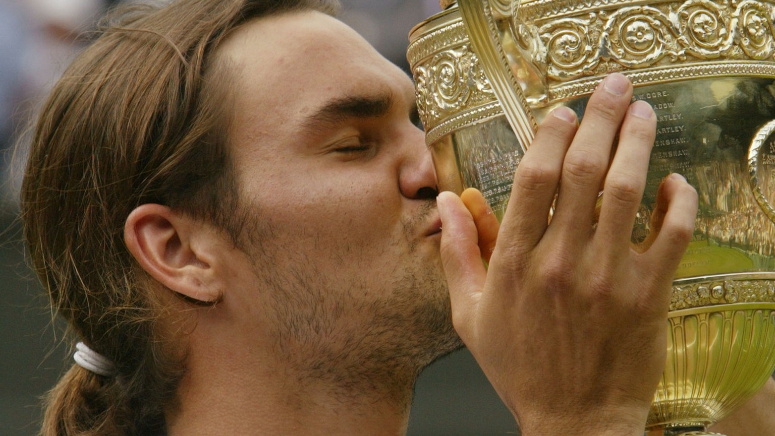 Switzerland&#039;s Roger Federer kisses the Men&#039;s Singles trophy after defeating Australia&#039;s Mark Philippoussis in the final of the All England Lawn Tennis Championships on the Centre Court  ...
