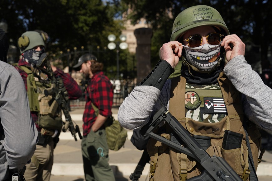 Armed demonstrators stand outside the locked gates of the Texas State Capitol, Sunday, Jan. 17, 2021, in Austin, Texas. (AP Photo/Eric Gay)