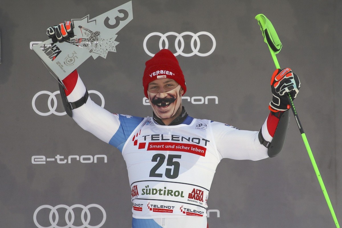Switzerland's Justin Murisier sports a face mask as he celebrates on podium his third place in a alpine ski, men's World Cup giant slalom in Alta Badia, Italy, Sunday, Dec.20, 2020. (AP Phot ...