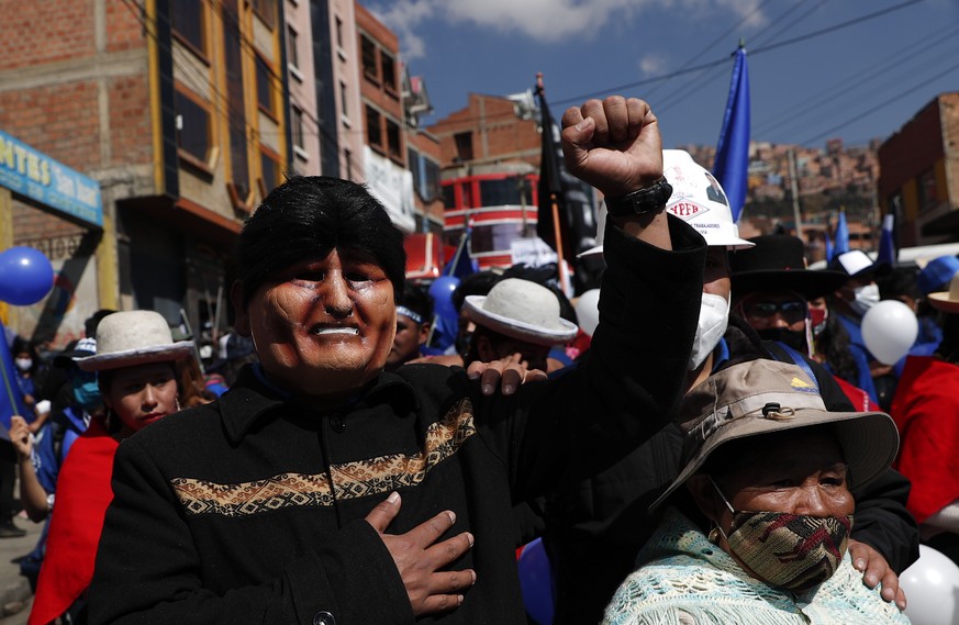 FILE - In this Sept. 19, 2020 file photo, a supporter, wearing a mask depicting former President Evo Morales, strikes a pose during a campaign rally for Luis Arce Catacora, the Bolivian presidential c ...