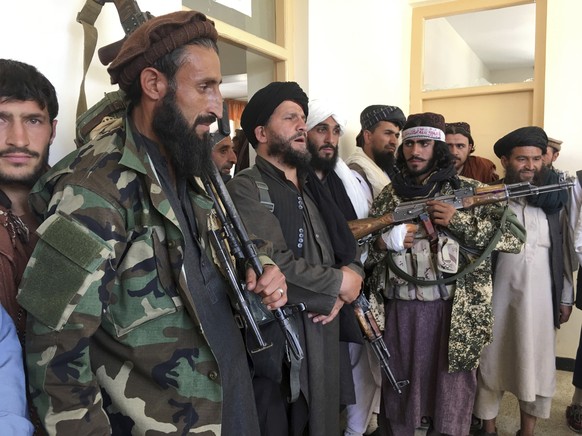 Taliban soldiers stand guard over surrendered Afghan Militiamen in the Kapisa province northeast of Afghanistan, Wednesday, Sept. 8, 2021. (AP Photo/Mohammad Asif Khan)