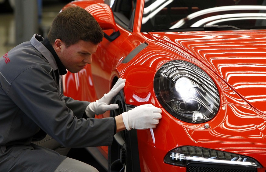 A worker with the new Porsche 911 GT3 RS sports car in the final check area at the Porsche factory in Stuttgart-Zuffenhausen, March 10, 2015. Porsche announced its 2014 results on Friday during its an ...