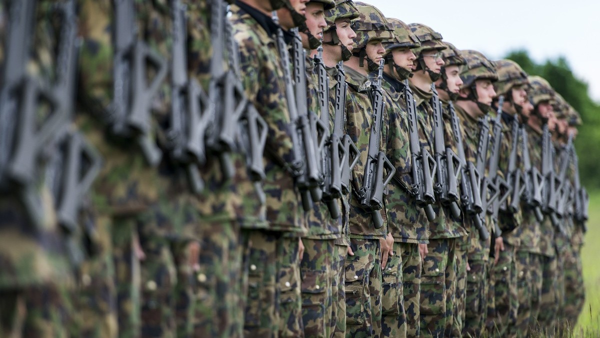 Infantry recruits stand in a row on a green field, pictured on May 17, 2013, in the infantry recruit school of the Swiss army in Colombier, canton of Neuchatel, Switzerland. (KEYSTONE/Christian Beutle ...